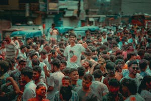 A colorful crowd enjoying the Holi festival on bustling city streets, capturing joyful moments.