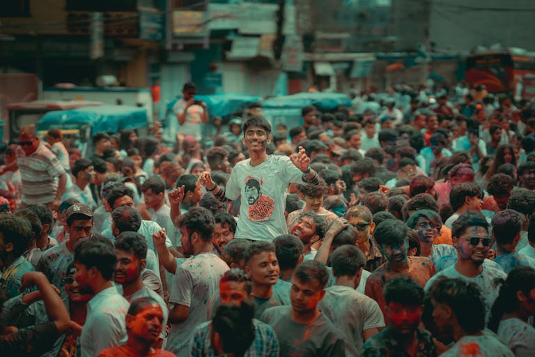 A colorful crowd enjoying the Holi festival on bustling city streets, capturing joyful moments.